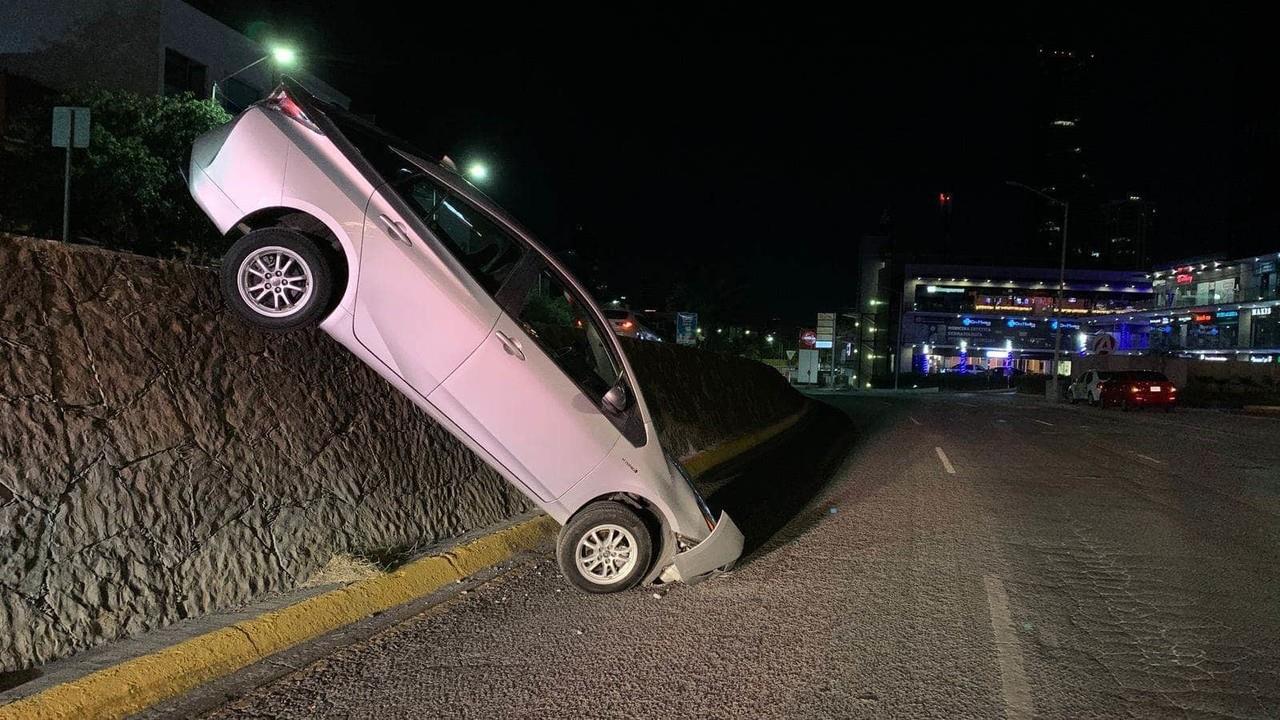 Cae automovilista de paso a desnivel y queda con el motor punta abajo