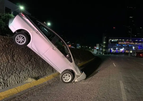 Cae automovilista de paso a desnivel y queda con el motor punta abajo