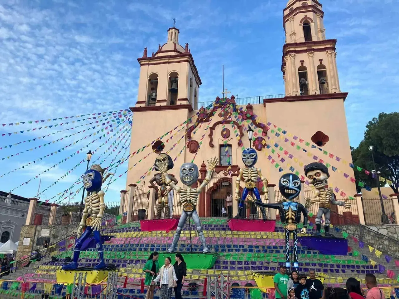 Paseantes se toman selfie con luchadores en altar de muertos de Santiago
