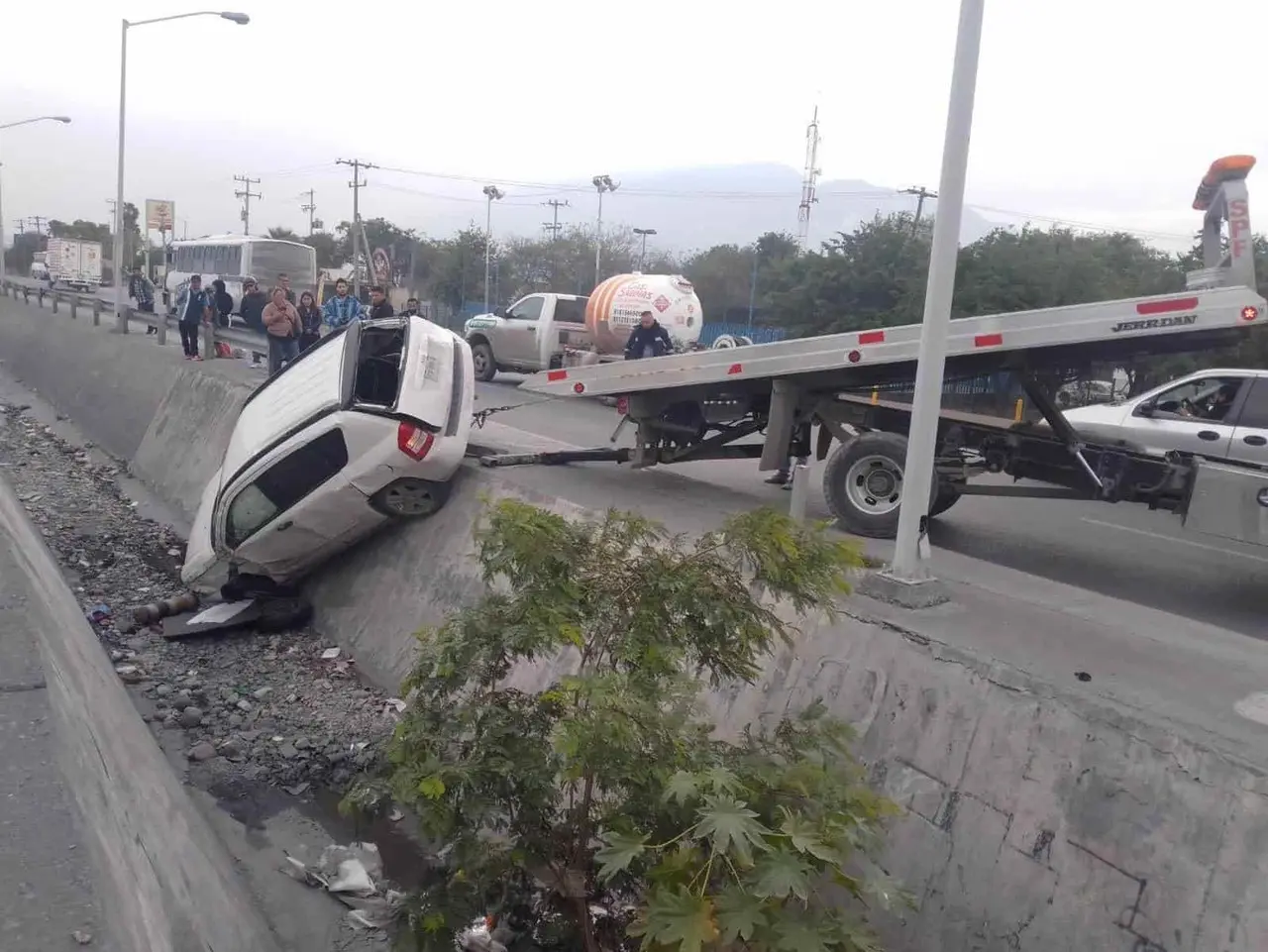 Hombre vuelca y cae camioneta al canal; grúa batalla para sacarla