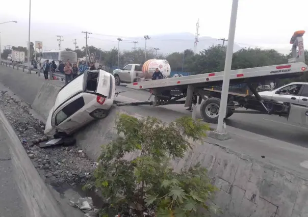 Hombre vuelca y cae camioneta al canal; grúa batalla para sacarla