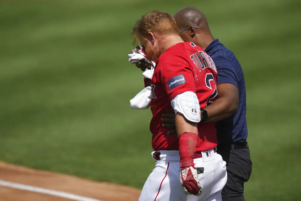 El pelotero de los Medias Rojas de Boston Justin Turner abandona el campo tras recibir un pelotazo en la cara en un lanzamiento del pitcher de los Tigres de Detroit Matt Manning en el encuentro de pretemporada el lunes 6 de marzo del 2023. (AP Foto/Gerald 