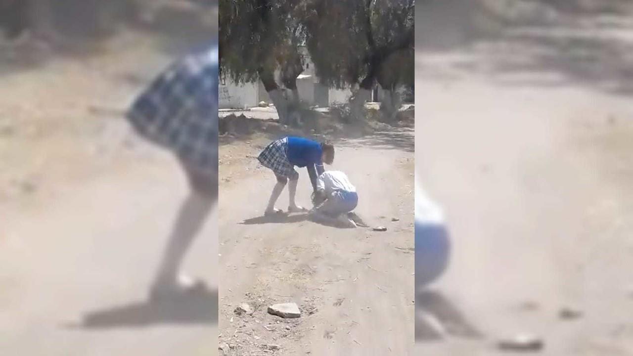 En un video difundido a través de redes sociales se difundieron las imágenes donde se aprecia cómo la presunta bulleadora golpea a la víctima con una piedra. Foto: Especial/ captura de pantalla