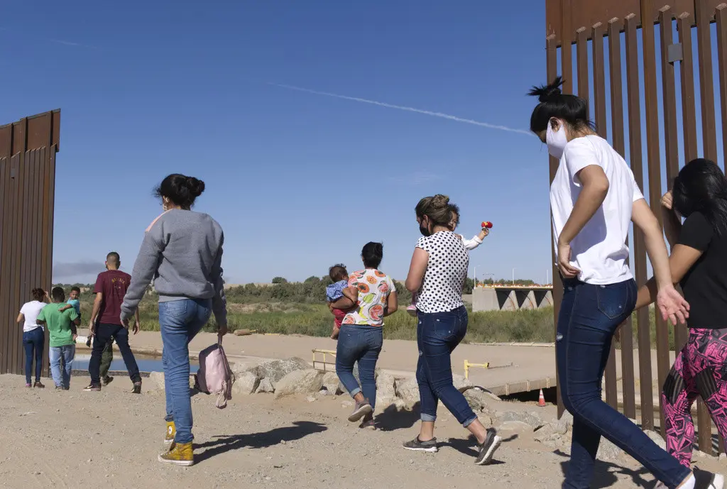 Un grupo de migrantes brasileños ingresan a Estados Unidos desde México por una brecha del muro fronterizo, en Yuma, Arizona, con el fin de solicitar asilo a las autoridades migratorias estadounidenses, el 8 de junio de 2021. (AP Foto/Eugene Garcia, archiv