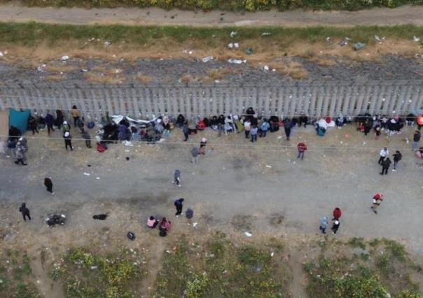 Duermen migrantes al lado del muro fronterizo de Tijuana