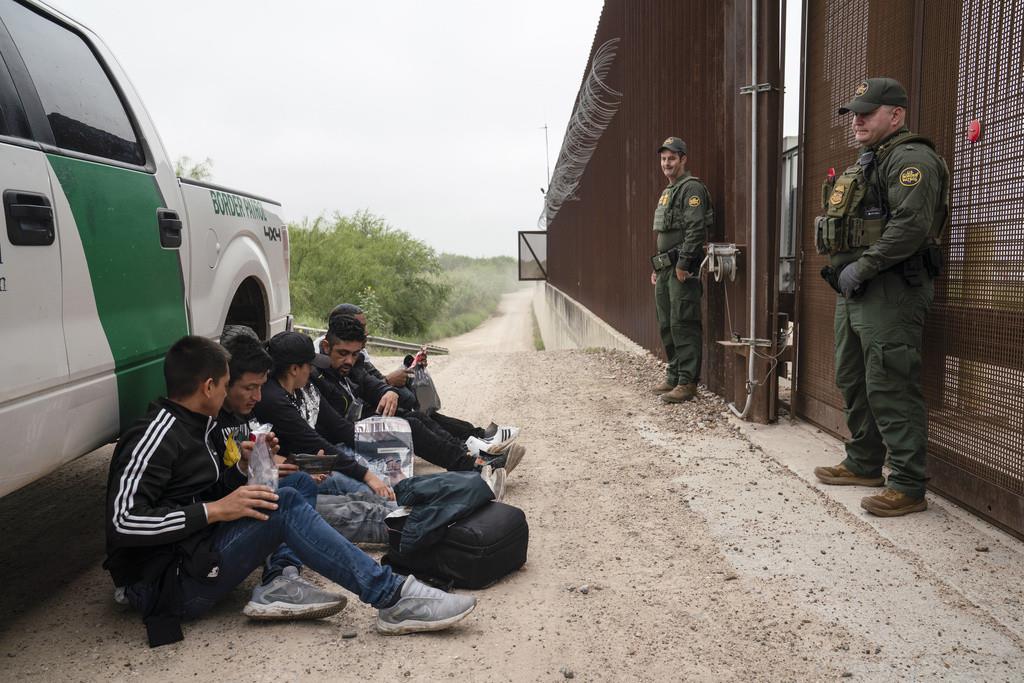 Migrantes colombianos que trataban de cruzar a Estados Unidos sin autorización legal esperan ser procesados por agentes de la Patrulla Fronteriza estadounidense el jueves 4 de mayo de 2023, cerca del cruce fronterizo en Hidalgo, Texas. (AP Foto/Veronica G.