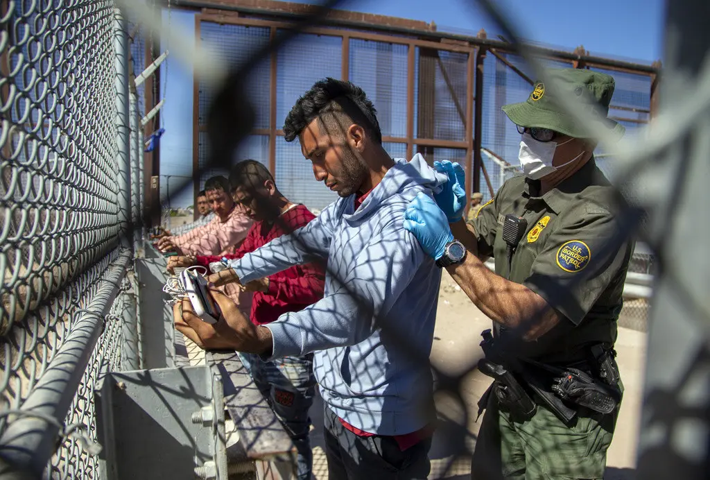 Migrantes son cacheados por un agente de la Patrulla Fronteriza al entrar a El Paso, Texas, desde Ciudad Juárez, México, el miércoles 10 de mayo de 2023. (AP Foto/Andres Leighton, Archivo)