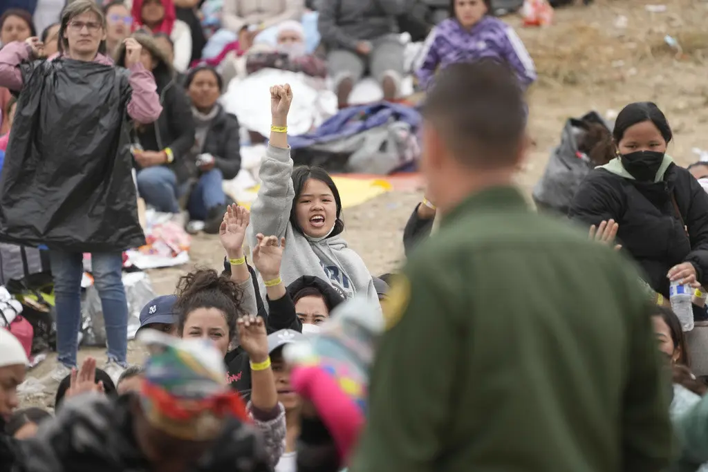 Mujeres muestran sus pulseras con la esperanza de ser elegidas por los agentes de la Patrulla Fronteriza de Estados Unidos para que su solicitud de asilo se atendida, luego de una espera de días entre los dos muros fronterizos, el viernes 12 de mayo de 202