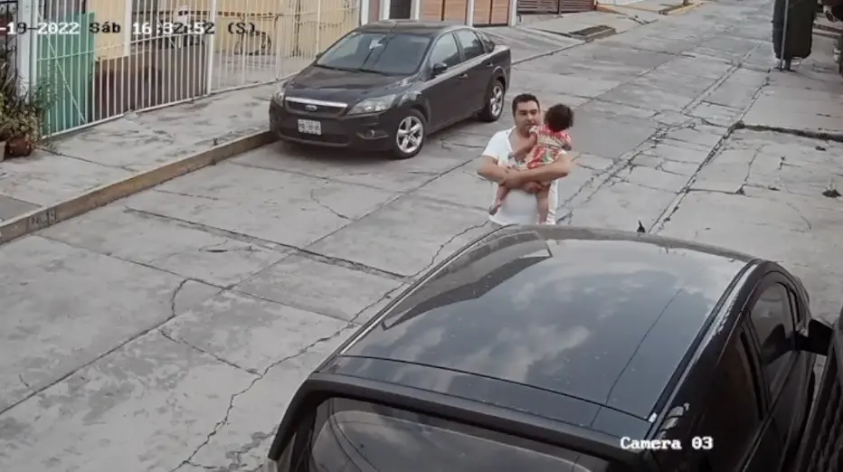 Luis Antonio Cornejo camina por la vía cargando a la menor en sus brazos.