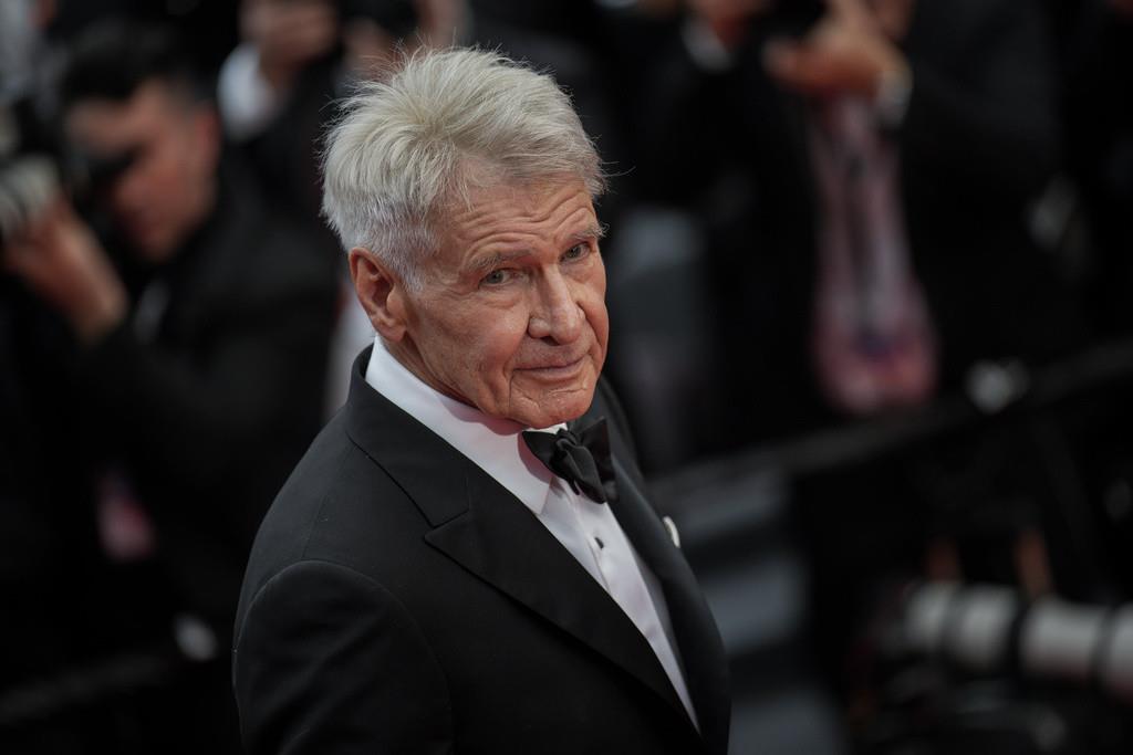 Harrison Ford posa a su llegada al estreno de la película Indiana Jones and the Dial of Destiny en la 76a edición del festival internacional de cine de Cannes, en sur de Francia, el jueves 18 de mayo de 2023. (Foto Vianney Le Caer/Invision/AP)