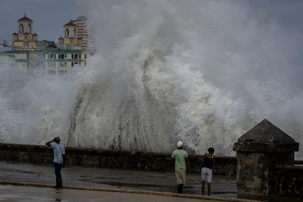 Unas personas en un muelle mientras olas enormes chocan contra el muro previo a la llegada del huracán Ian en La Habana, Cuba, el miércoles 28 de septiembre de 2022. (AP Foto/Ramon Espinosa, Archivo)