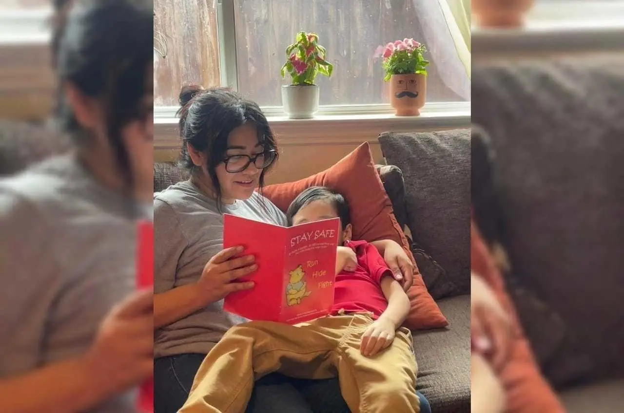 Cindy Campos lee Stay Safe a su hijo de 5 años, en Dallas. El libro aconseja a los niños qué hacer si el peligro está cerca, como cerrar puertas con llave, apagar las luces y esconderse en silencio hasta que llegue la policía. (Cindy Campos vía AP)