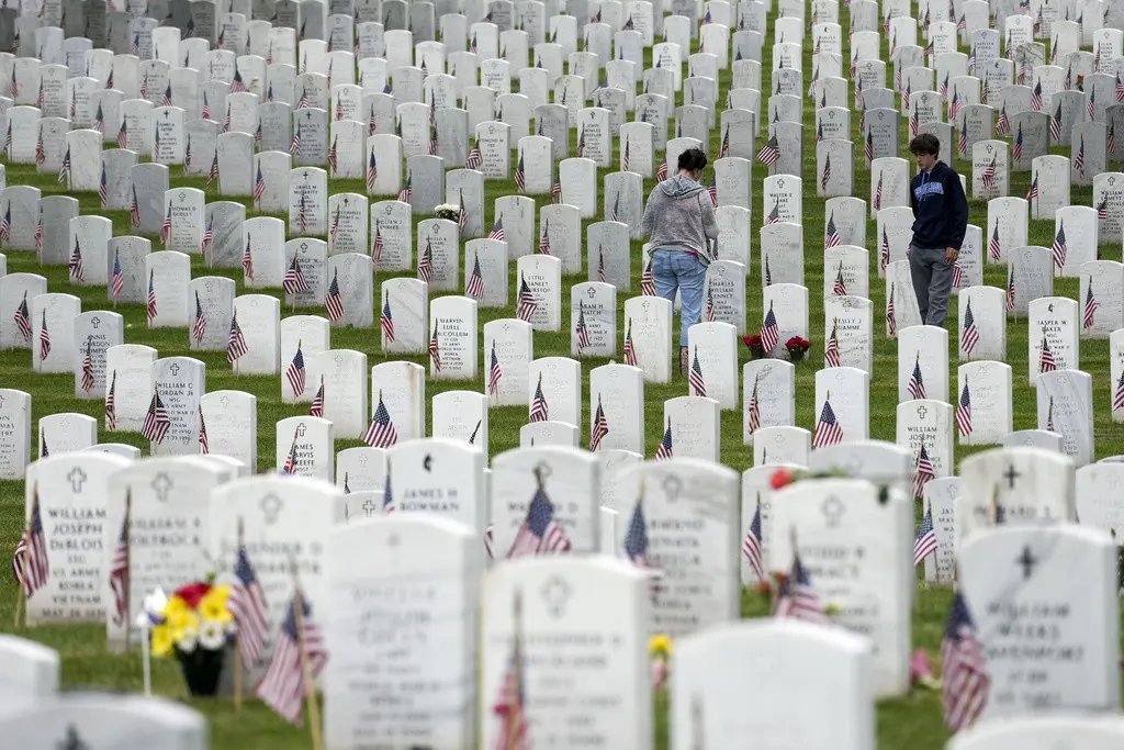 Personas caminan entre las lápidas mientras visitan la Sección 60 del Cementerio Nacional Arlington durante el Día de los Caídos en Guerras, el lunes 29 de mayo de 2023, en Arlington, Virginia. (AP Foto/Alex Brandon)