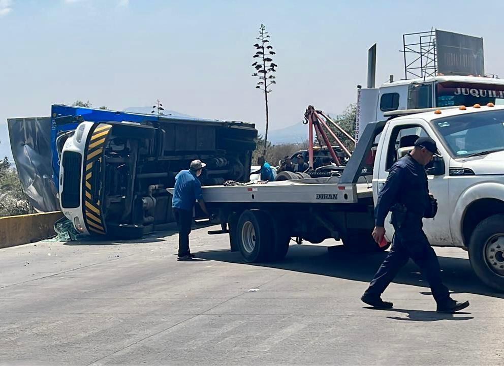 Personal de bomberos y protección civil acudieron y apoyaron en las maniobras para traspalear la carga que quedó regada en la cinta asfáltica al resguardo de la policía municipal. Foto: Especial.