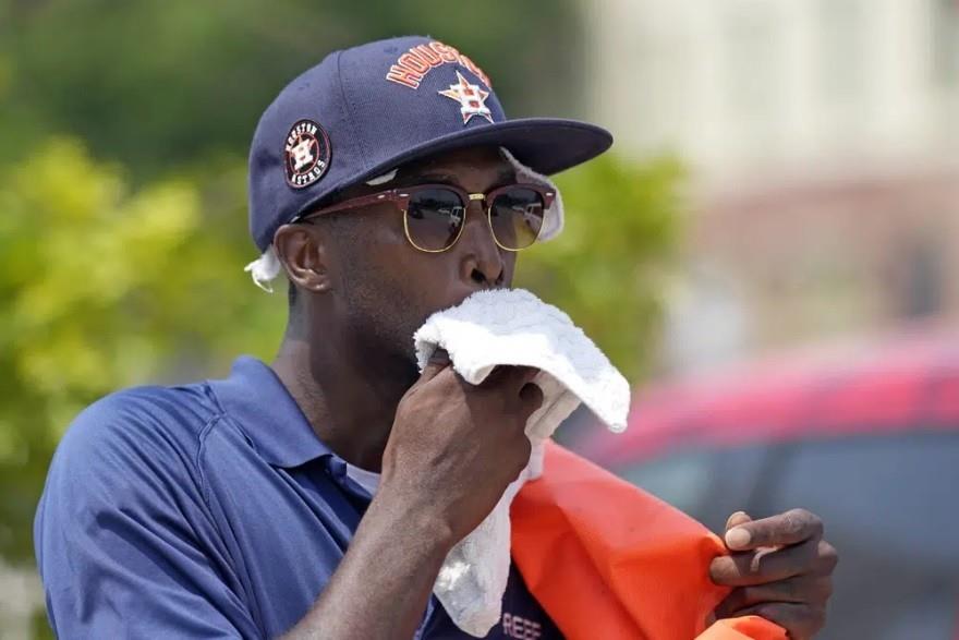 Donnay Wright, quien trabaja en un estacionamiento, se limpia el sudor del rostro mientras trabaja afuera del Minute Maid Park, en Houston. (AP Foto/David J. Phillip)