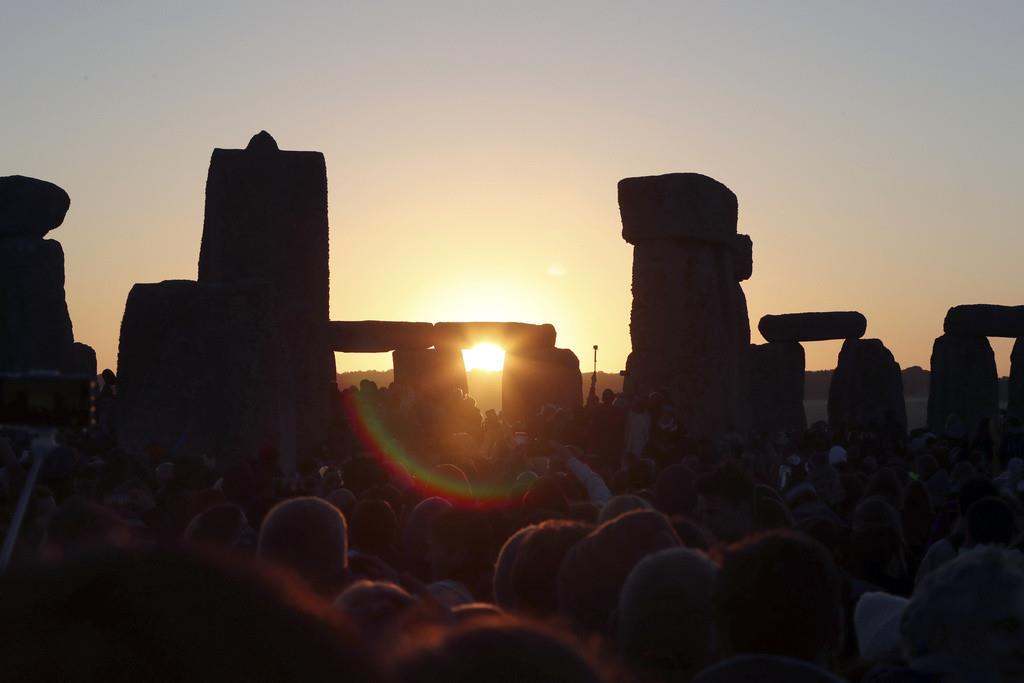 El sol sale frente a miles de personas que se reunieron en Stonehenge para celebrar el solsticio de verano, el día más largo del año, el viernes 21 de junio de 2019, cerca de Salisbury, Inglaterra. (AP Foto/Aijaz Rahi, Archivo)