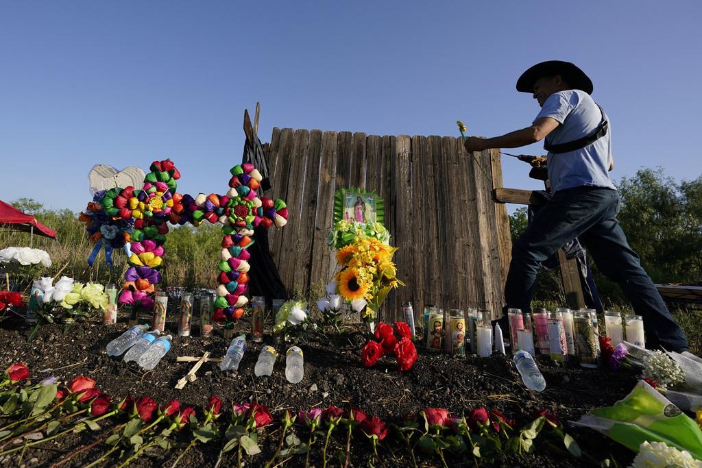 Roberto Marquez, de Dallas, coloca una flor el 29 de junio de 2022, en un altar instalado donde las autoridades estadounidenses encontraron a decenas de personas muertas en un camión de carga, en San Antonio, Texas. (AP Foto/Eric Gay, Archivo)