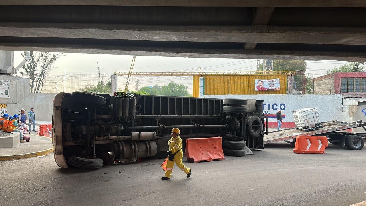 Camión de carga termina volcado tras golpear puente vehicular