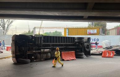 Camión de carga termina volcado tras golpear puente vehicular