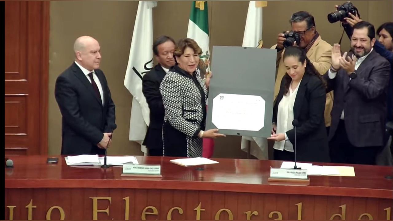 Recibe Delfina Gómez Álvarez la constancia de mayoría que la acredita como gobermadora electa del Estado de México. Es la primera mujer en gobernar la entidad y la primera en ser de un partido distinto al PRI. Foto: Captura de pantalla