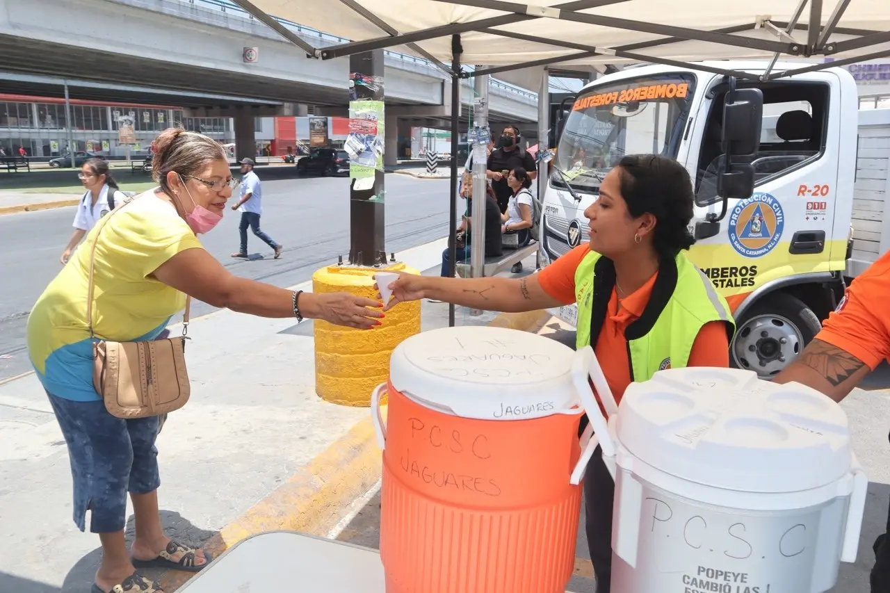 En los módulos de hidratación dispuestos desde principios de junio anterior, personal del Grupo Jaguares de Protección Civil y del DIF municipales reparten el vital líquido a los transeúntes. Foto: Municipio de Santa Catarina