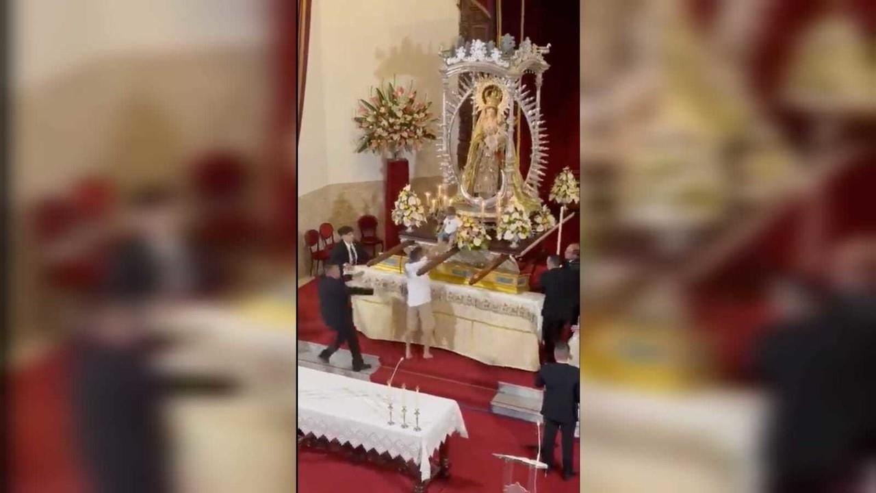 El hombre, entrando descalzo a la iglesia, llevaba al pequeño cargado a los hombros. Una vez dentro, corrió hacia el altar mayor con la intención de situar al niño lo más cerca posible de la imagen de la virgen. Foto: Captura de pantalla