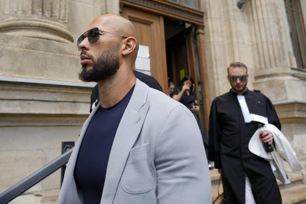 Andrew Tate sale de la sede de la corte de apelaciones seguido por su abogado, Eugen Vidineac, en Bucarest, Rumanía, el 1 de agosto de 2023. (AP Foto/Andreea Alexandru)