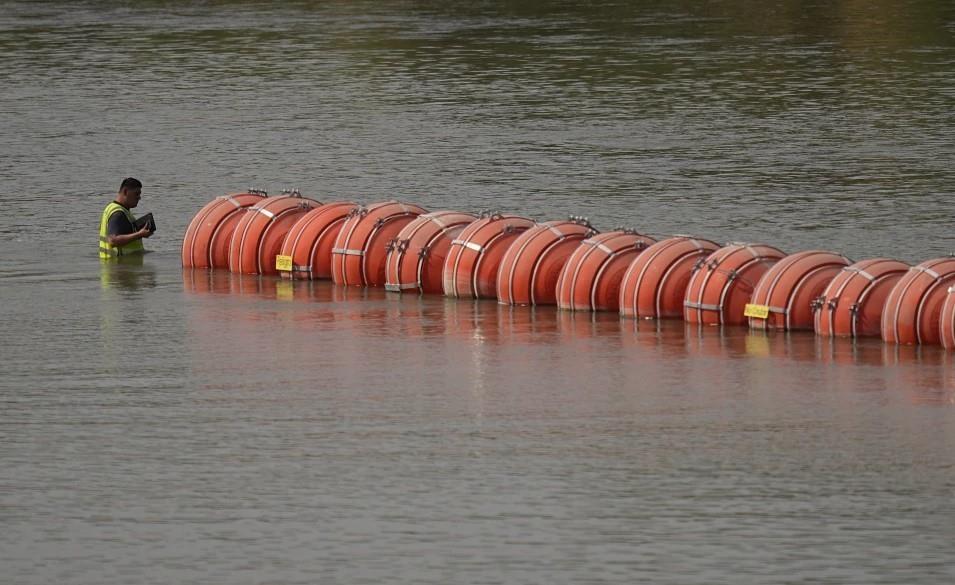 Un trabajador inspecciona las boyas utilizadas como barrera a lo largo del río Bravo _Rio Grande en Estados Unidos_ el lunes 21 de agosto de 2023, en Eagle Pass, Texas. (AP Foto/Eric Gay)