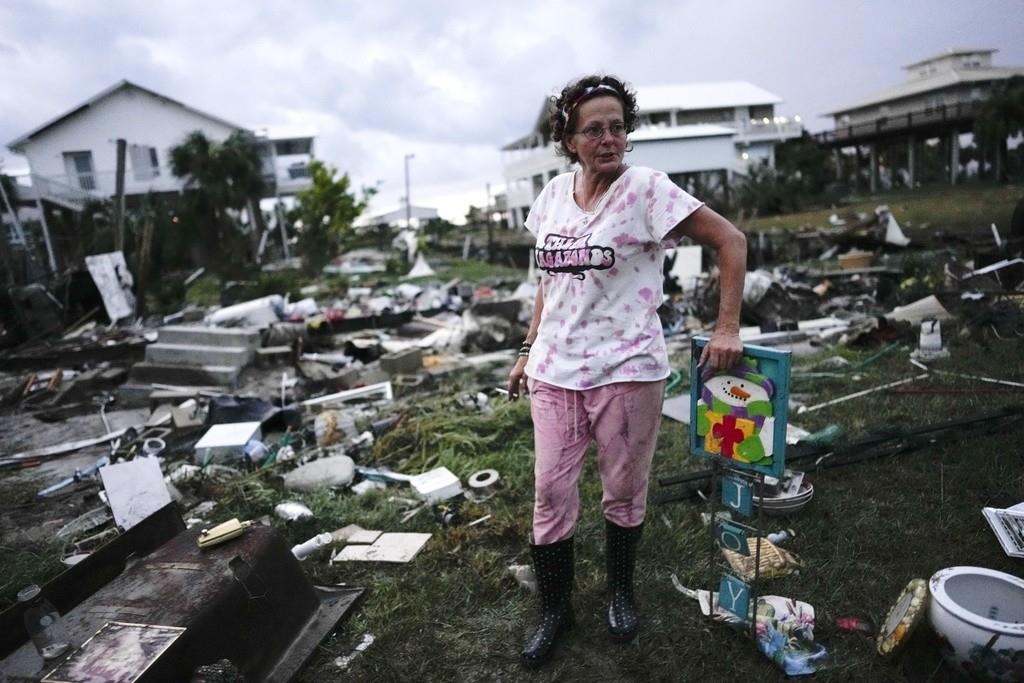 Jewell Baggett, de pie junto a una decoración navideña que recuperó de entre los restos de la casa de su madre, mientras busca otras pertenencias en la casa rodante que su abuelo adquirió. (AP Foto/Rebecca Blackwell)