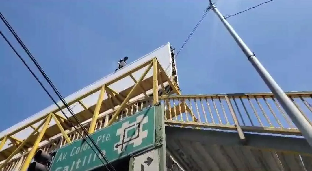 Policías  rescataron a un joven que se encontraba en la parte alta de un puente peatonal.  Foto. Cortesía