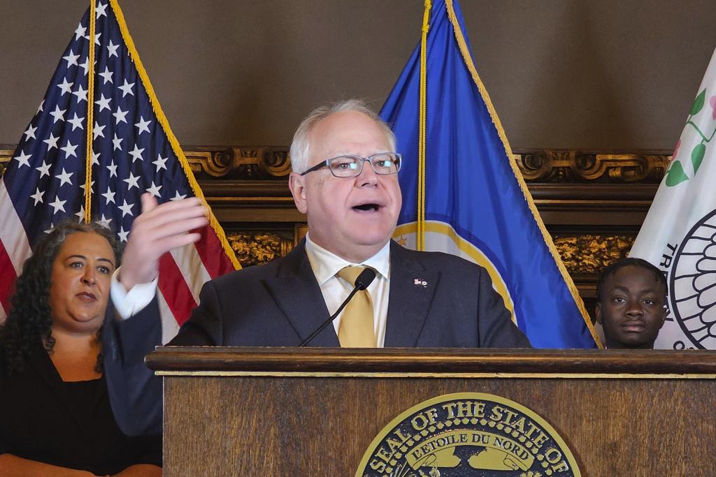 Partidarios, políticos y autores de la ley celebran luego de que el gobernador de Minnesota, Tim Walz (centro), promulga la ley “Licencia de conducir para todos”, en St. Paul, Minnesota, el 7 de marzo de 2023. (Elizabeth Flores/Star Tribune vía AP)