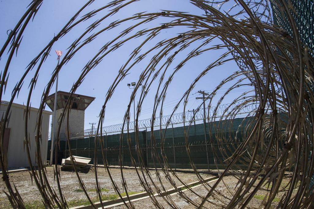 En esta foto del 17 de abril de 2019, revisada por el mando militar, se ve la torre de control a través de la alambrada de púas en la prisión Camp VI de la base naval de Guantánamo, Cuba. (AP Foto/Alex Brandon, File)