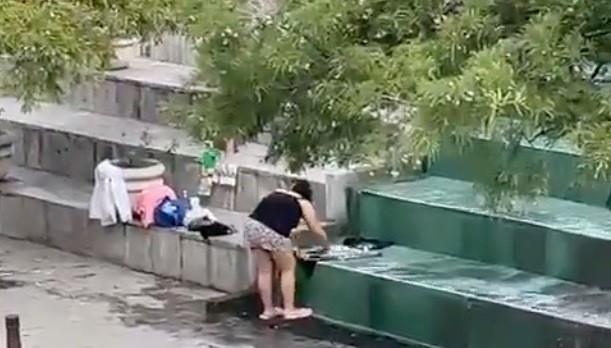 En las imágenes se alcanza a observar el momento en el que la mujer está tallando con jabón en mano un pantalón mientras aprovecha el agua que cae por los escalones. Foto: X @DeTodoUnPoco677.