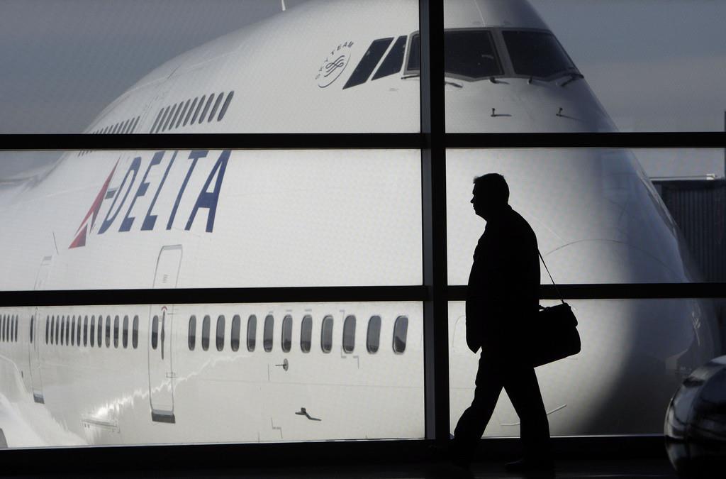 Un pasajero pasa frente a un avión 747 de Delta Airlines en el aeropuerto de Romulus, Michigan, el 21 de enero de 2010. (Foto AP/Paul Sancya, Archivo)