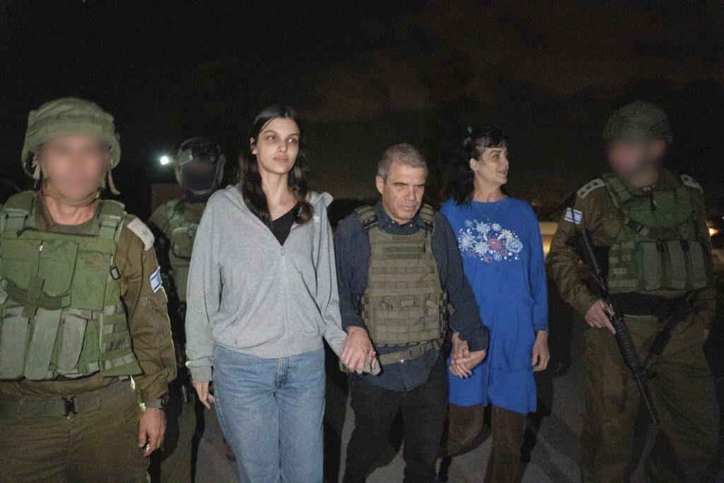 En esta fotografía proporcionada por el gobierno de Israel, Judith Raanan (derecha) y su hija de 17 años de edad, Natalie, son escoltadas por soldados israelíes y Gal Hirsch.  (Gobierno de Israel vía AP Foto)