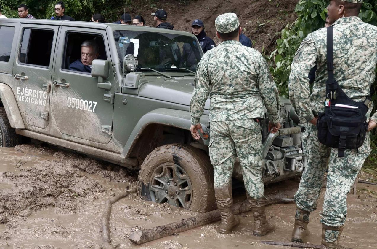 Durante el trayecto, el convoy presidencial se vio obligado a avanzar con dificultad debido a los árboles caídos y el lodo que alcanzaba hasta las rodillas. Foto: Rodrigo OROPEZA / AFP