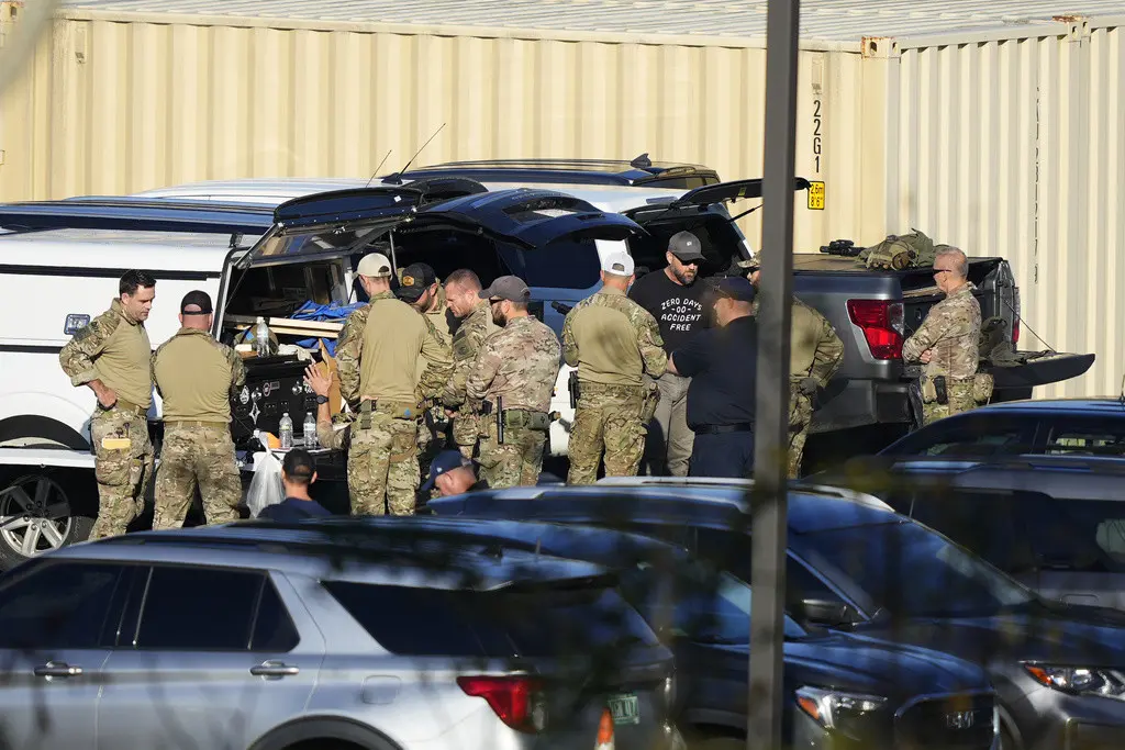 Agentes se reúnen en el estacionamiento de una escuela en la búsqueda de Robert Card, un reservista del ejército al que las autoridades acusan de matar a tiros a 18 personas, el viernes 27 de octubre de 2023, en Lewiston, Maine. (AP Foto/Matt Rourke)