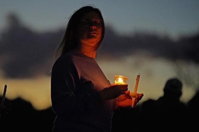 Una persona asiste a una vigilia para las víctimas de los tiroteos masivos de esta semana el sábado, 28 de octubre de 2023 en Lisbon Falls, Maine. (AP Foto/Robert F. Bukaty)