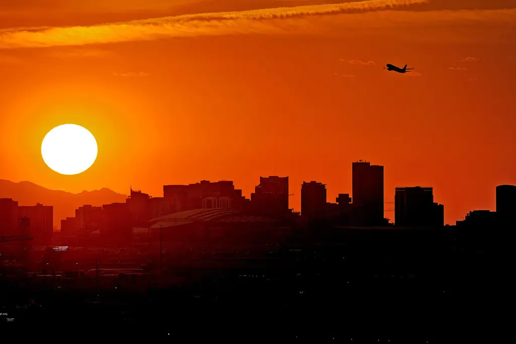 Un avión despega desde el Aeropuerto Internacional Sky Harbor mientras el sol se pone sobre Phoenix, Arizona, el 12 de julio de 2023. (Foto AP/Matt York, Archivo)