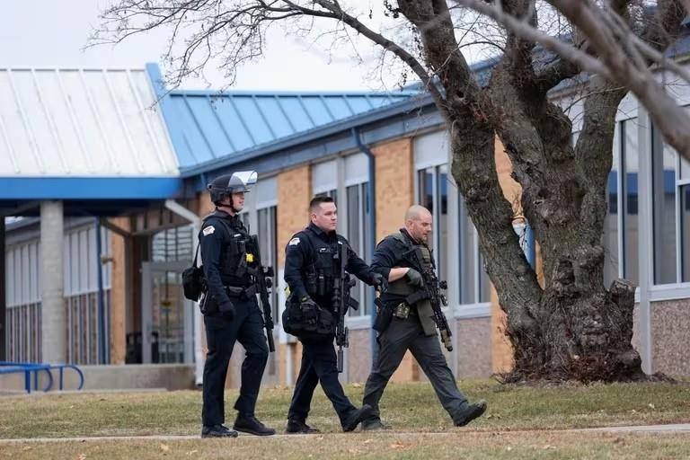 Agentes acercándose a la escena a las afueras de la secundaria Perry High School. Fuente: Reuters