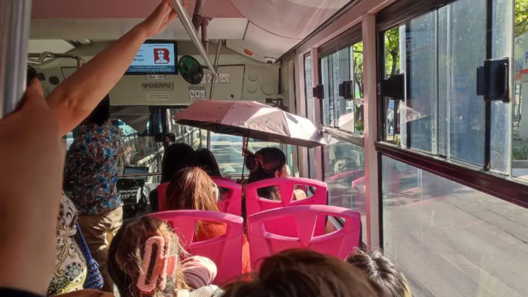 ¡Hace calor! Una mujer viajaba muy comoda con sombrilla abierta en Metrobús