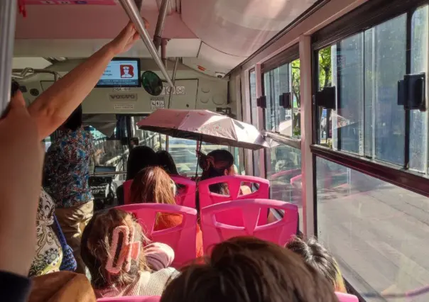 ¡Hace calor! Una mujer viajaba muy comoda con sombrilla abierta en Metrobús