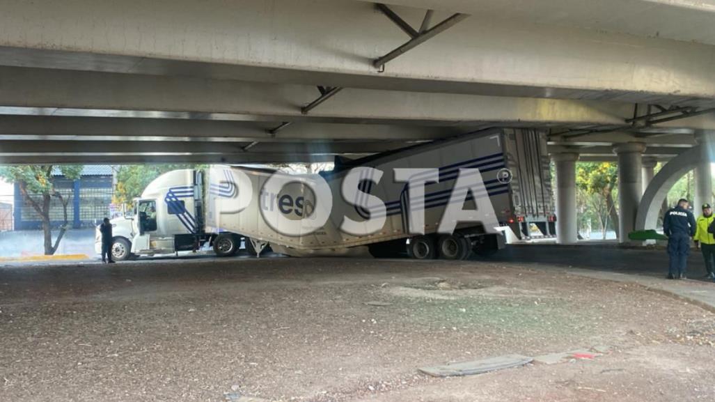 ¡Pobres perritos! Tráiler que transportaba alimento canino se atora bajo puente