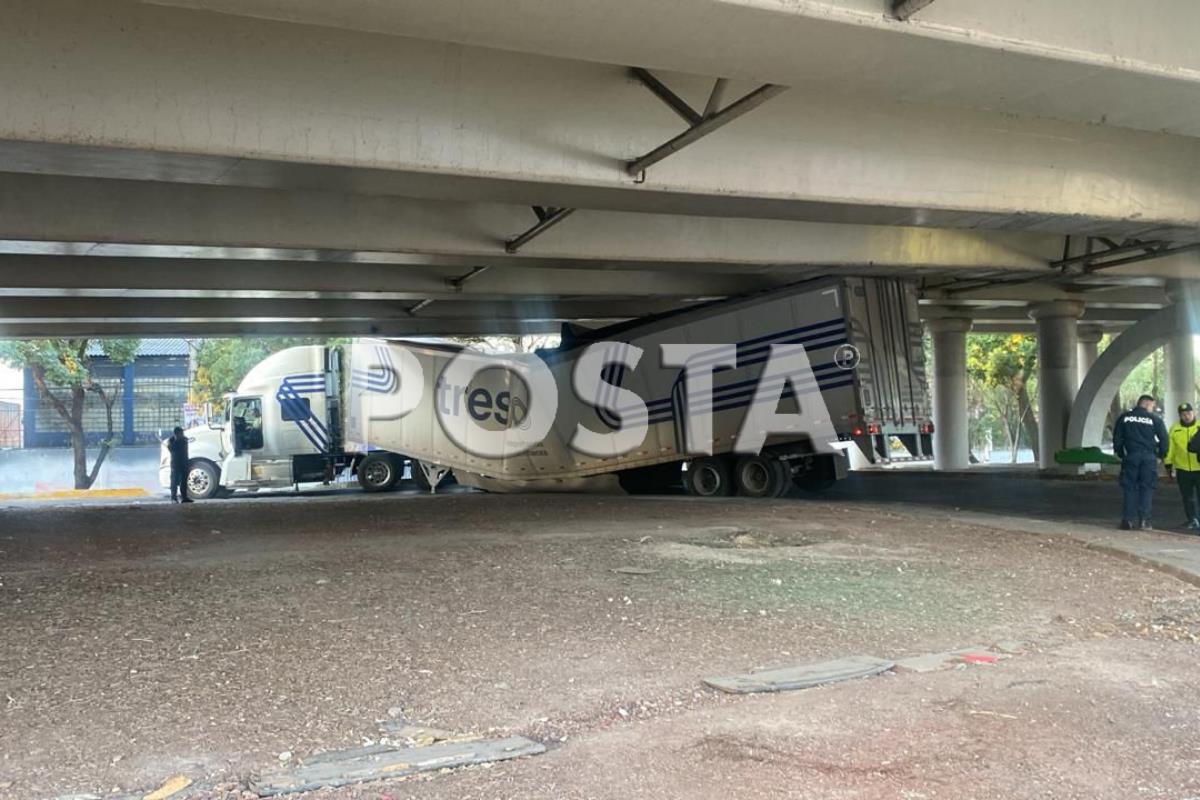 ¡Pobres perritos! Tráiler que transportaba alimento canino se atora bajo puente.      Foto: Ramón Ramírez