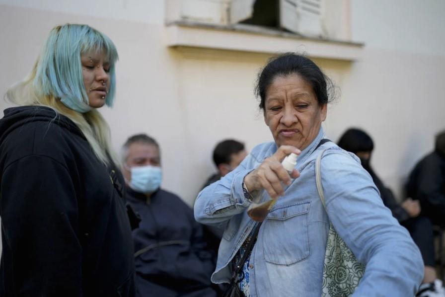 Una mujer se aplica un repelente casero contra mosquitos hecho con vainilla y agua mientras espera a ser atendida en un hospital en medio de un aumento en los casos de dengue, en Buenos Aires, Argentina,. Foto. AP Foto/Natacha Pisarenko)