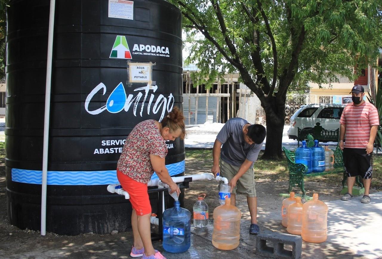 Vecinos rellenan los botes de agua o garrafones en un parque. Foto: Archivo/POSTA