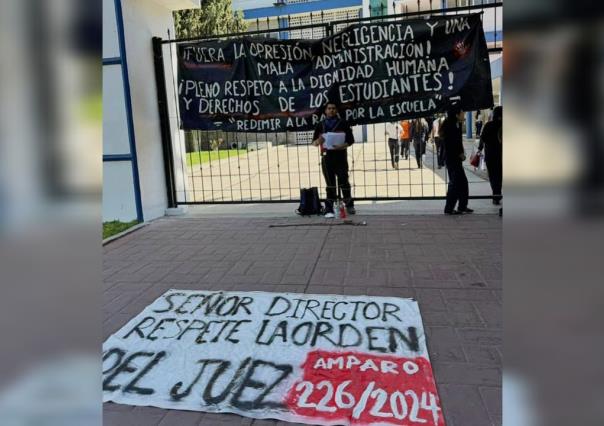 Estudiante protesta encadenado afuera de la ByCENED. Denuncia injusticias