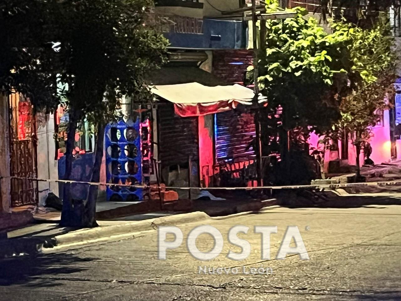 El cuerpo del hombre cubierto con una sabana blanca al exterior de la tienda de abarrotes. Foto: Rafael Enríquez