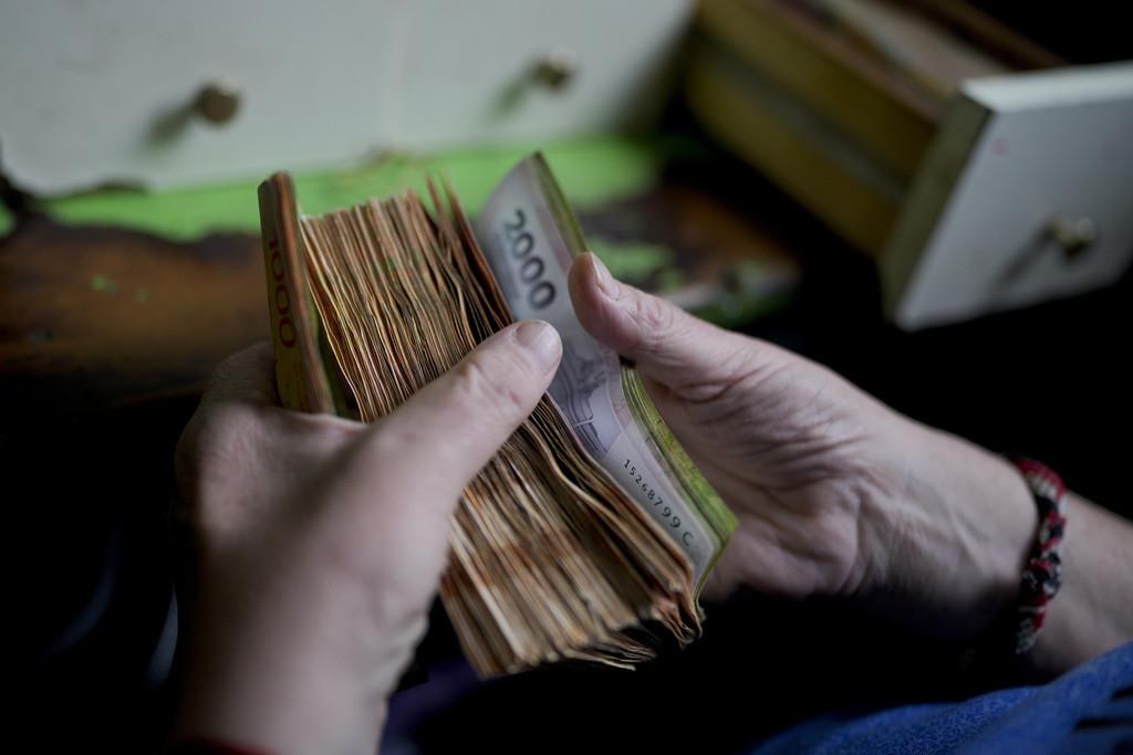 Un trabajador cuenta el dinero en una tienda de abarrotes en Buenos Aires, Argentina, 21 de noviembre de 2023. (AP Foto/Natacha Pisarenko, Archivo)