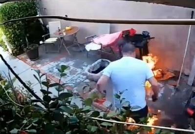 El hombre tratando de sofocar el fuego que provocó en su asador. Foto: X @sstrange_world.